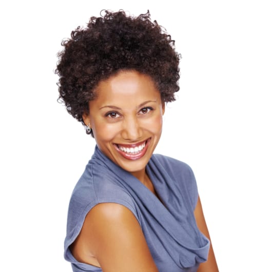 Smiling woman wearing a blue cowl neck blouse in front of a solid white background.