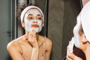 woman applying skin mask in mirror