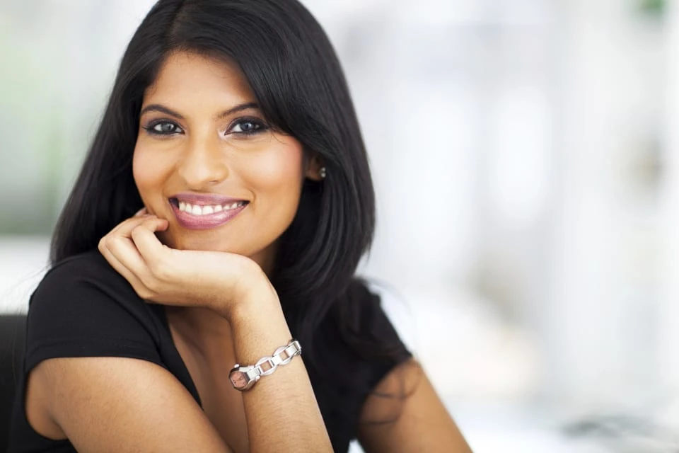 Smiling businesswoman leaning her chin on her hand.