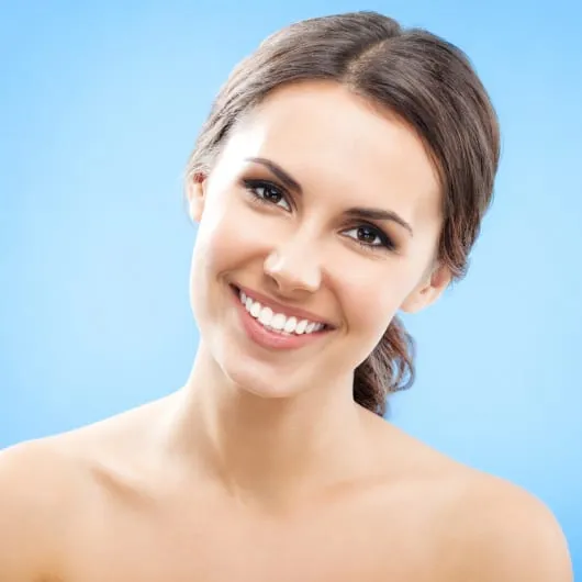 microneedling_small_image Portrait of beautiful young happy smiling woman with long curly hair, over blue background.
